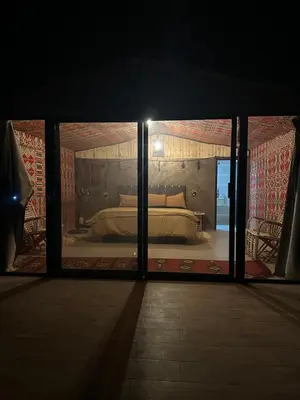 a bedroom with a bed in a room with windows at Wadirum momoo in Wadi Rum