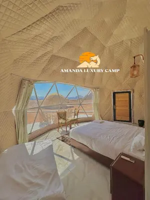 a tent with two beds in a room with a view at Amanda Luxury Camp in Wadi Rum