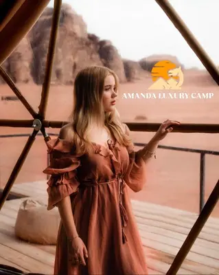 a woman in a brown dress standing on a bridge at Amanda Luxury Camp in Wadi Rum