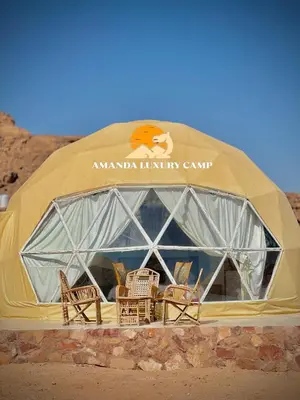 a tent with chairs and tables in the desert at Amanda Luxury Camp in Wadi Rum