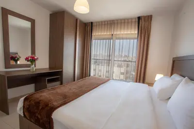 a hotel room with a large bed and a window at Triple A Hotel Suites in Amman