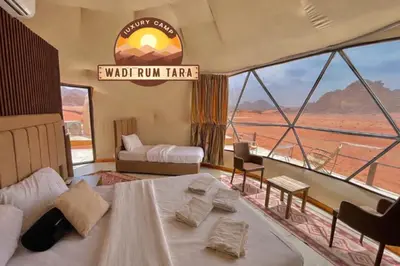 a room with a bed and a view of the desert at WADI RUM TARA lUXURY CAMP in Wadi Rum