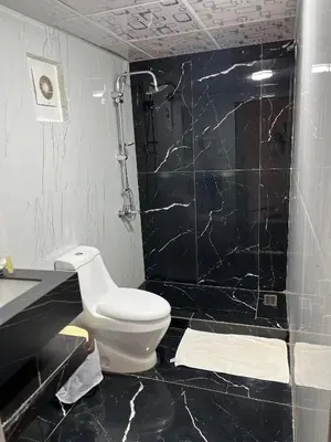 a black and white bathroom with a toilet and a shower at WADI RUM TARA lUXURY CAMP in Wadi Rum