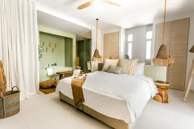 a bedroom with a large white bed and a bathroom at Cloud 7 Residence Ayla Aqaba in Aqaba
