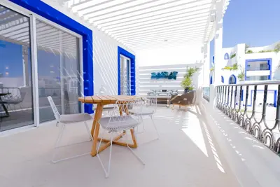 a patio with a table and chairs on a balcony at Cloud 7 Residence Ayla Aqaba in Aqaba
