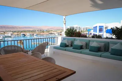 a couch on a balcony with a view of the water at Cloud 7 Residence Ayla Aqaba in Aqaba