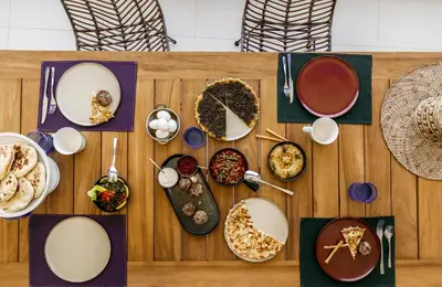 a wooden table with plates of food on it at Cloud 7 Residence Ayla Aqaba in Aqaba