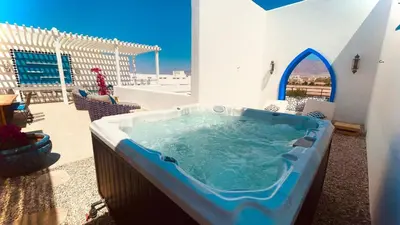a hot tub in a room with a patio at Cloud 7 Residence Ayla Aqaba in Aqaba
