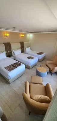 a hotel room with three beds and a couch at Jordan Seasons Hotel in Aqaba