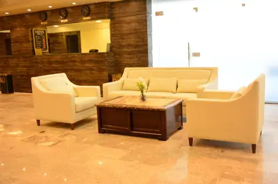 a living room with two chairs and a coffee table at Rakeen Hotel in Amman