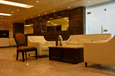 a lobby with a couch and a table and chairs at Rakeen Hotel in Amman
