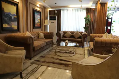 a living room with brown couches and a table at Post Boutique Hotel Amman in Amman