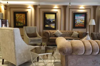 a living room with couches and a table and chairs at Post Boutique Hotel Amman in Amman