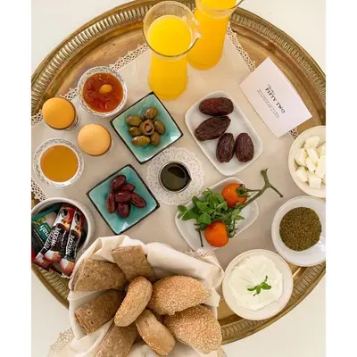 a table with a tray of breakfast foods and orange juice at Nu Fifty Two in Amman