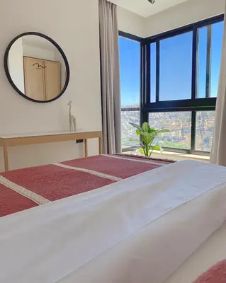 a bedroom with a large bed and a mirror at Nu Fifty Two in Amman