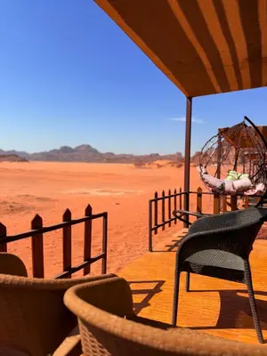 a porch with chairs and a ferris wheel in the desert at NAEL BEDOUIN lUXURY CAMP in Wadi Rum