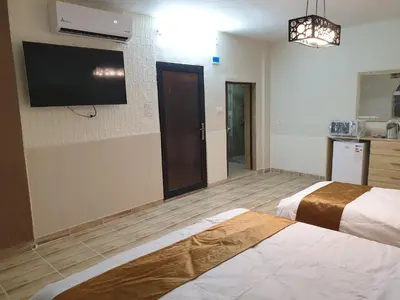 a hotel room with two beds and a flat screen tv at atoom studio in Jerash
