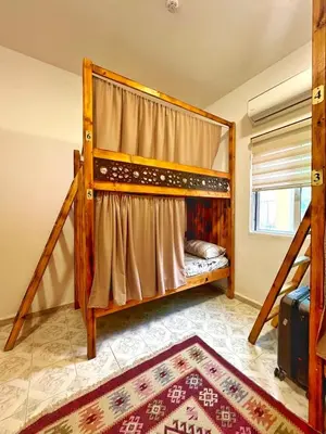 a bedroom with two bunk beds and a rug at Hakaia Community in Aqaba