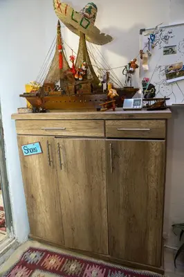 a wooden cabinet with a pirate ship on top of it at Hakaia Community in Aqaba
