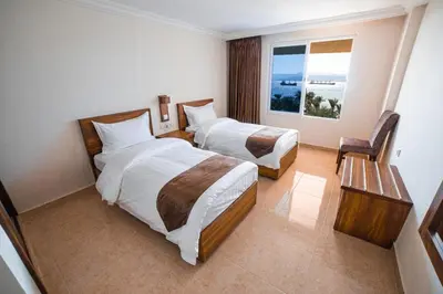 a hotel room with two beds and a window at Joar Beach Hotel in Aqaba