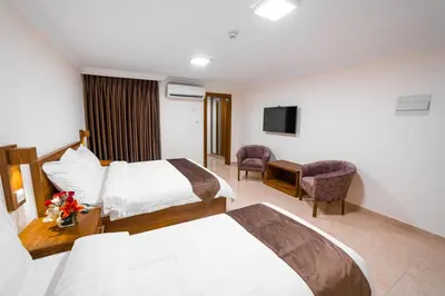 a hotel room with two beds and a television at Joar Beach Hotel in Aqaba