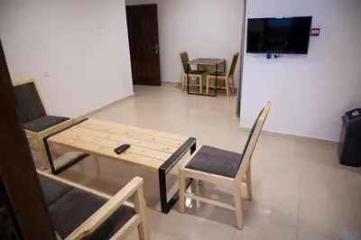 a living room with a table and chairs and a television at Dali House in Amman