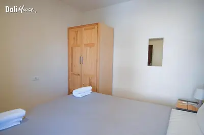 a bedroom with a bed and a wooden door at Dali House in Amman