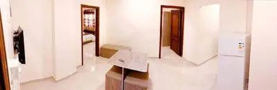 a room with a kitchen with a table and a refrigerator at RAWA'AT ALAQABA in Aqaba