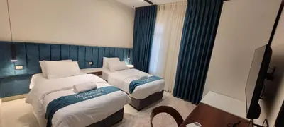a hotel room with two beds and a television at VILLA MARIA PETRA in Wadi Musa