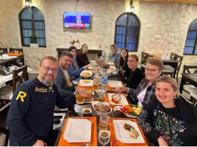 a group of people sitting at a table in a restaurant at Mount Nebo Hotel & Restaurant Madaba City Center in Madaba
