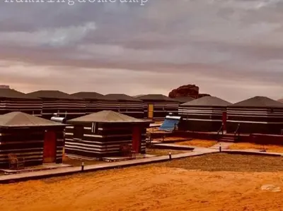a group of buildings with roofs in a field at Wadi Rum Marcanã camp in Aqaba