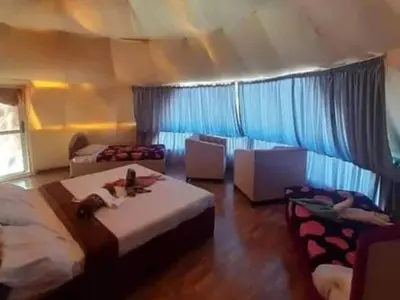 a bedroom with two beds and chairs in a room at Wadi Rum Marcanã camp in Aqaba