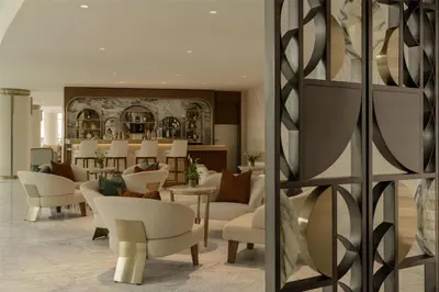 a lobby with white chairs and tables and a mirror at Signia by Hilton in Amman