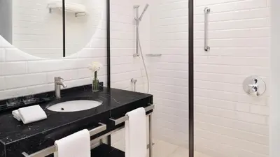 a white bathroom with a sink and a shower at InterContinental Amman Jordan by IHG in Amman