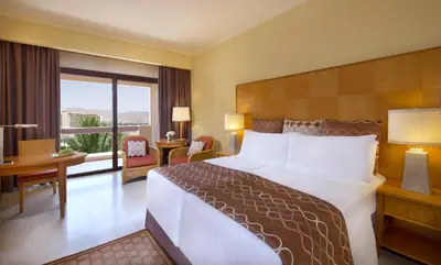 a hotel room with a large bed and a desk at InterContinental Aqaba by IHG in Aqaba