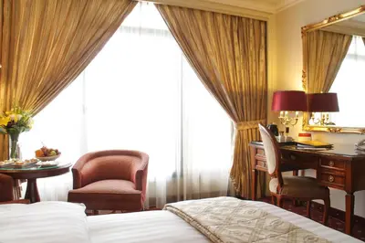 a hotel room with a desk and a bed at Regency Palace Amman in Amman