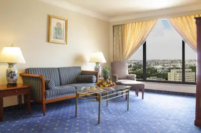 a living room with a couch and a table at Regency Palace Amman in Amman