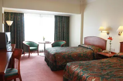 a hotel room with two beds and a table at Grand Palace Hotel in Amman