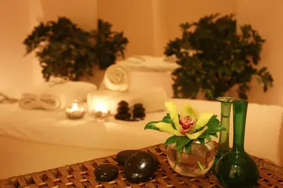 a table with a glass vase with a flower in it at Grand Palace Hotel in Amman