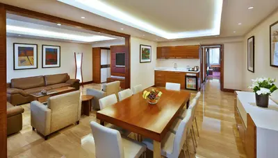 a dining room and living room with a table and chairs at Crowne Plaza Amman by IHG in Amman