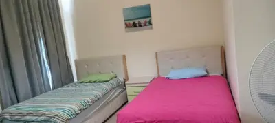 two beds sitting next to each other in a room at Gorgeous Pool View Apartment - Tala Bay Resort, Aqaba in Aqaba