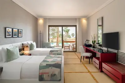 a hotel room with two beds and a television at Kempinski Hotel Ishtar Dead Sea in Sowayma