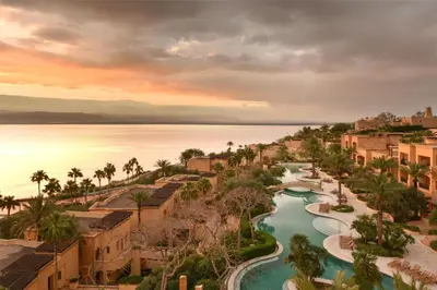 an aerial view of a resort with a river at Kempinski Hotel Ishtar Dead Sea in Sowayma