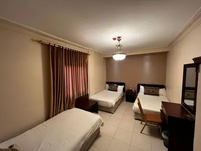 a hotel room with two beds and a desk at Salome Hotel in Madaba