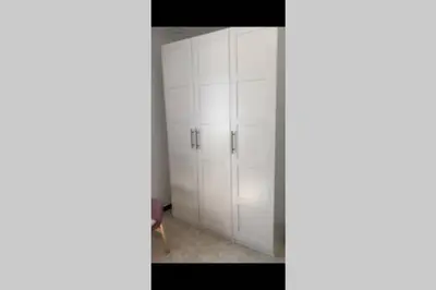 a closet with white cabinets in a room at Gedara Guesthouse: enjoy unforgettable scenes in Um Qeis