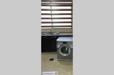 a washing machine in a kitchen next to a sink at Apt 4 rent/A quiet neighborhood close to services in Amman