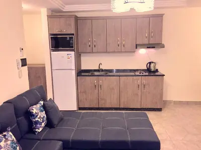 a living room with a couch and a kitchen at The Royal Luxury King Terrace 1 in Amman