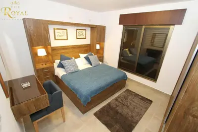 a bedroom with a bed and a mirror and a chair at The Royal Luxury Superior King in Amman