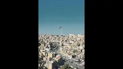 an aerial view of a city with a flag on top at The Royal Luxury City Budget Visit in Amman