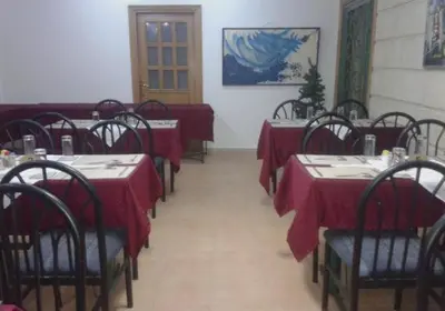 a dining room with tables with red table cloths at Razan Hotel in Amman